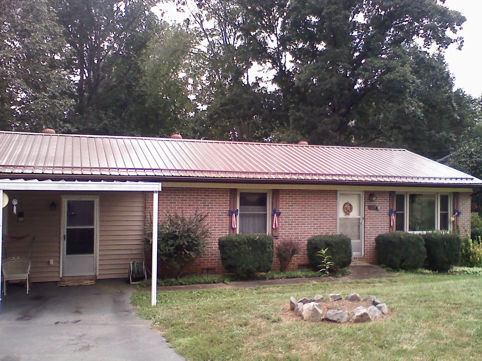 Bronze metal roof and carport on a brick ranch home — Roof Repair work by our crew in Prichard