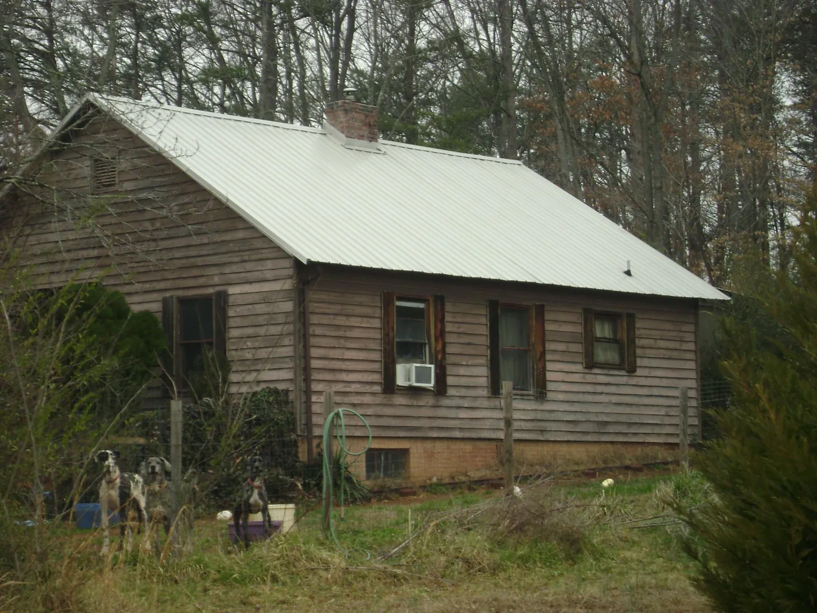 White metal roof on an old wood sided farmhouse, from a Asphalt Shingle Roof Repair job in Prichard